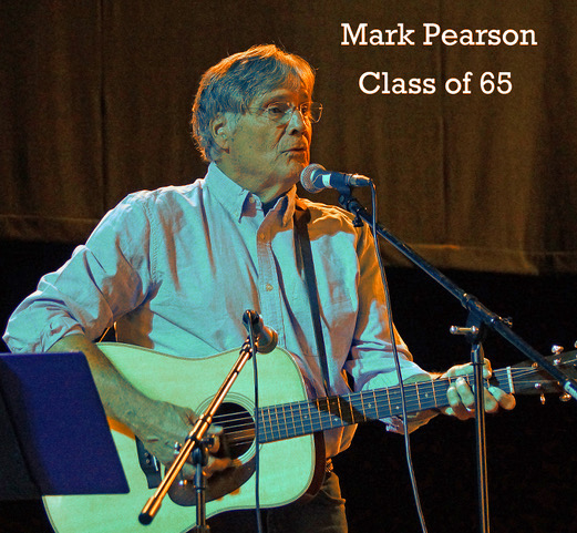 Mark on stage playing guitar in a pale blue shirt for the class of '65 concert