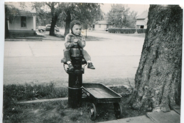 Young Mark Pearson riding a fire hydrant imagining himself on an adventure.
