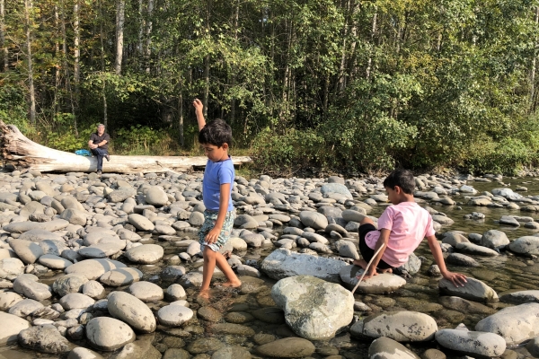 Boys playing in the stream on the rock