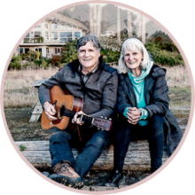 Mark Pearson sitting with a guitar and his wife, Pat