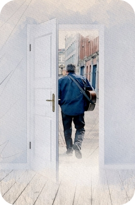 An open door with Mark walking down a road in old-town Seattle, holding a guitar