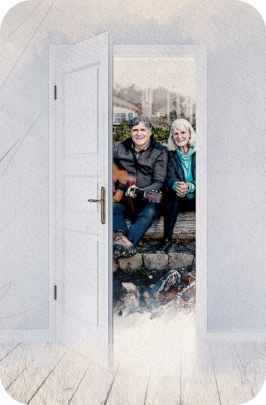 An open doorway showing Mark Pearson sitting with a guitar and his wife, Pat